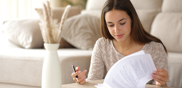 Femme lisant des documents à son domicile.