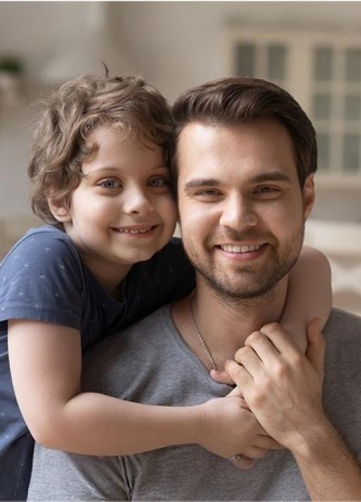 Un père et son enfant s’enlacent en souriant