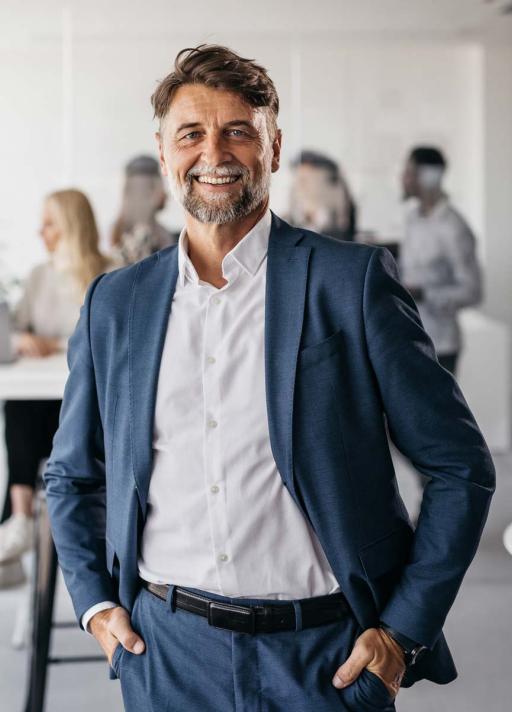 Homme souriant en veste et pantalon bleu foncé