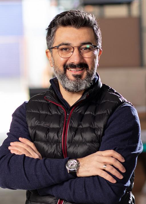 Un homme avec les bras croisés sourit