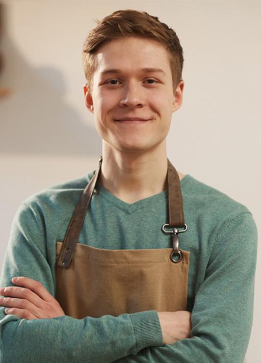 Un homme avec un tablier sourit