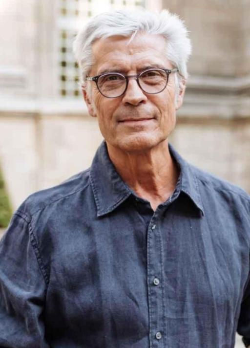 Homme aux cheveux blancs avec des lunettes souriant
