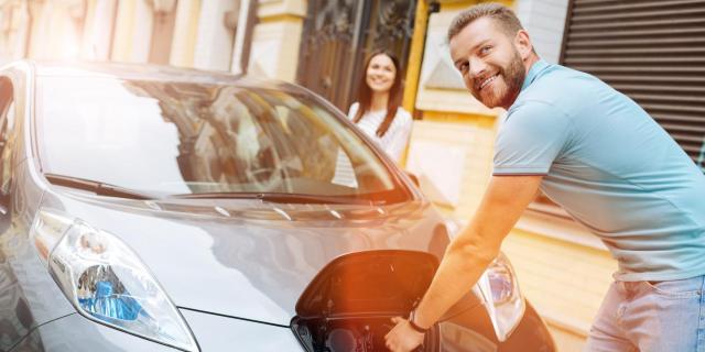 Homme recharge voiture électrique souriant-min_1