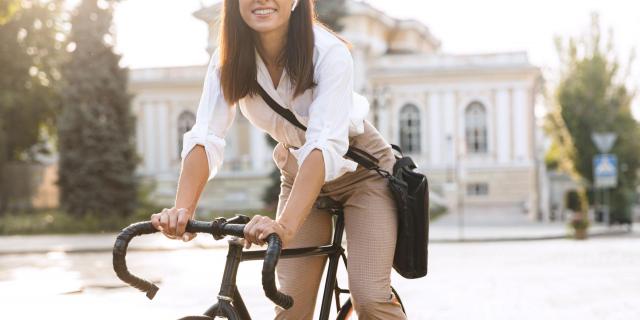 Une femme sur vélo devant une maison 
