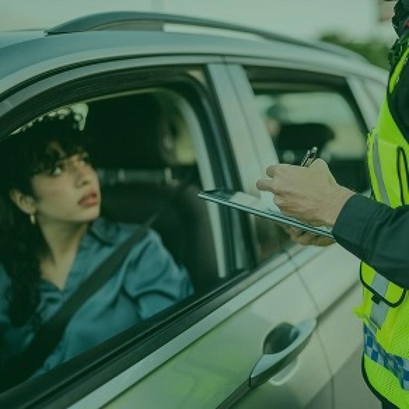 Femme au volant d'une voiture recevant une amende