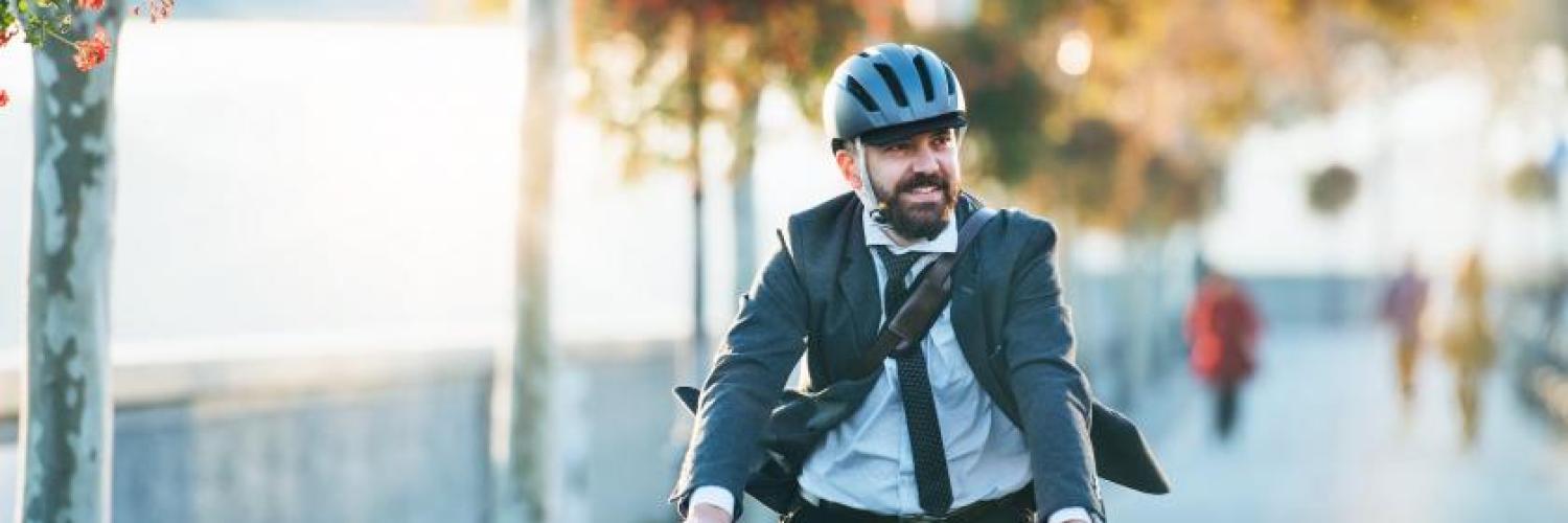 homme-sur-velo-casque-et-cravate-gettyimages-1130474656-min