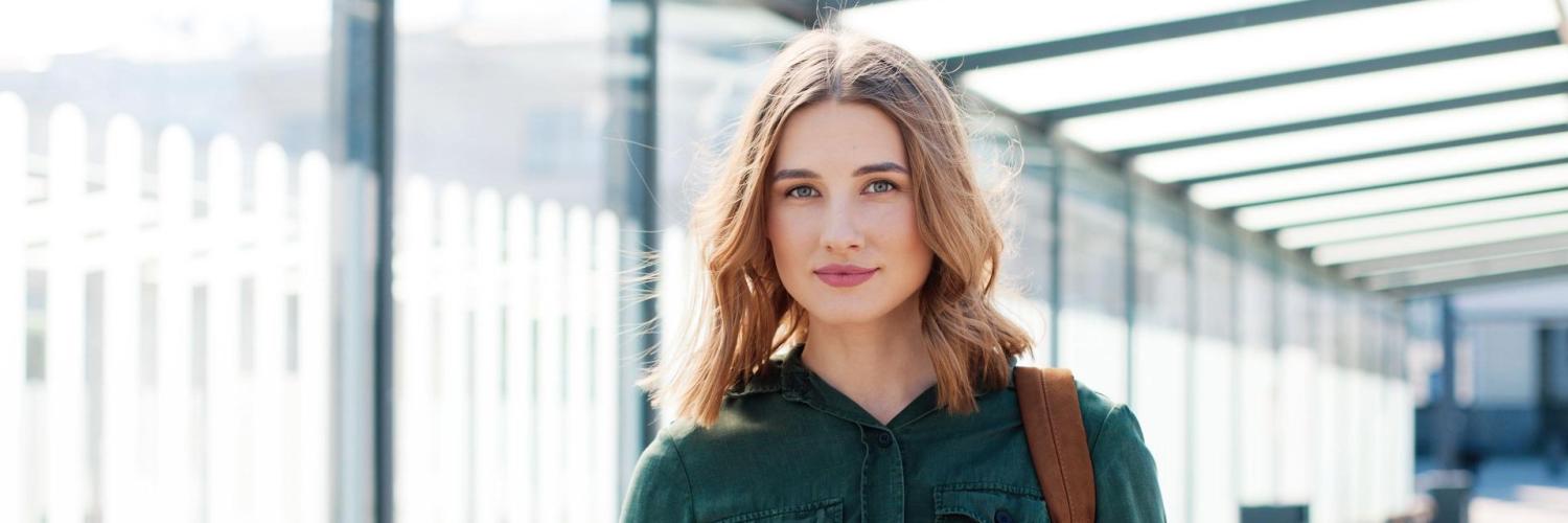 Femme sourit avec un portable à la main