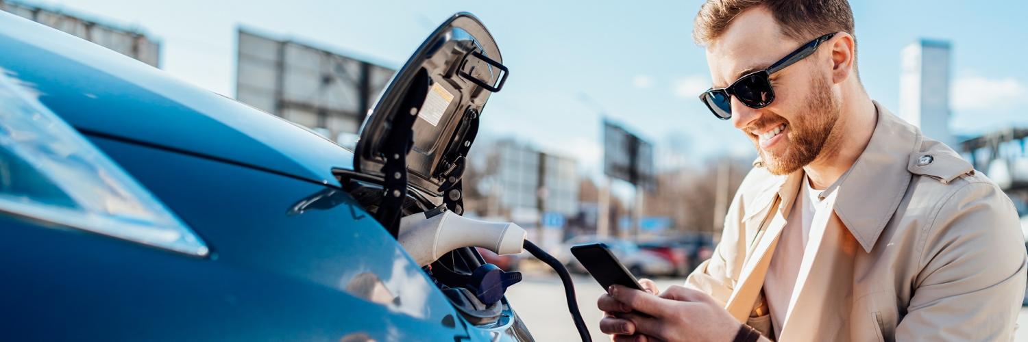 Homme rechargeant son véhicule électrique