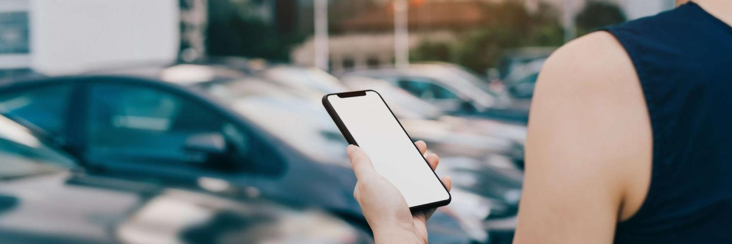 Jeune femme réservant sur son téléphone une voiture en autopartage