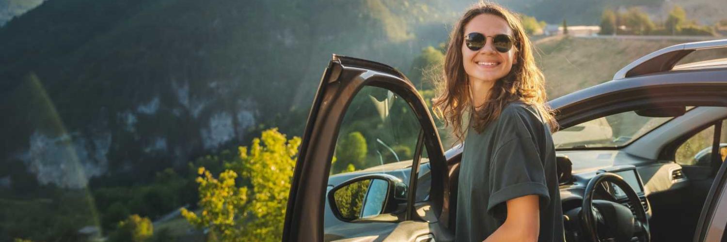 Femme souriante devant voiture Femme souriante devant voiture