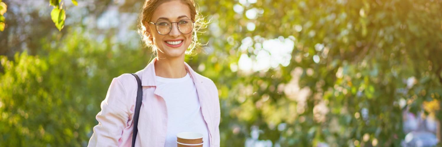 Visuel femme souriante tenant un gobelet