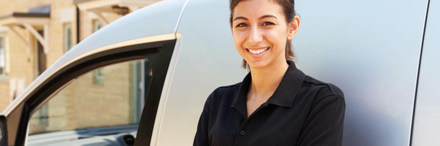 Visuel femme souriante adossée à une voiture