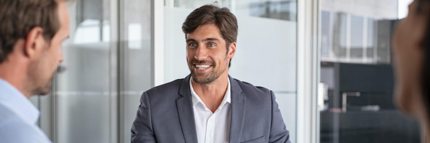 visuel homme souriant autour d'une table