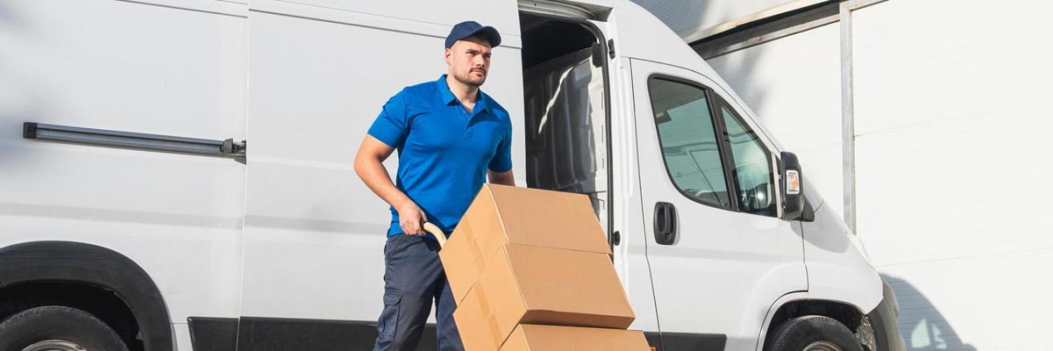 Un homme en uniforme de livraison déplace des cartons