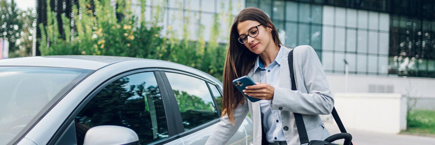 Une femme sur son téléphone près d'une voiture