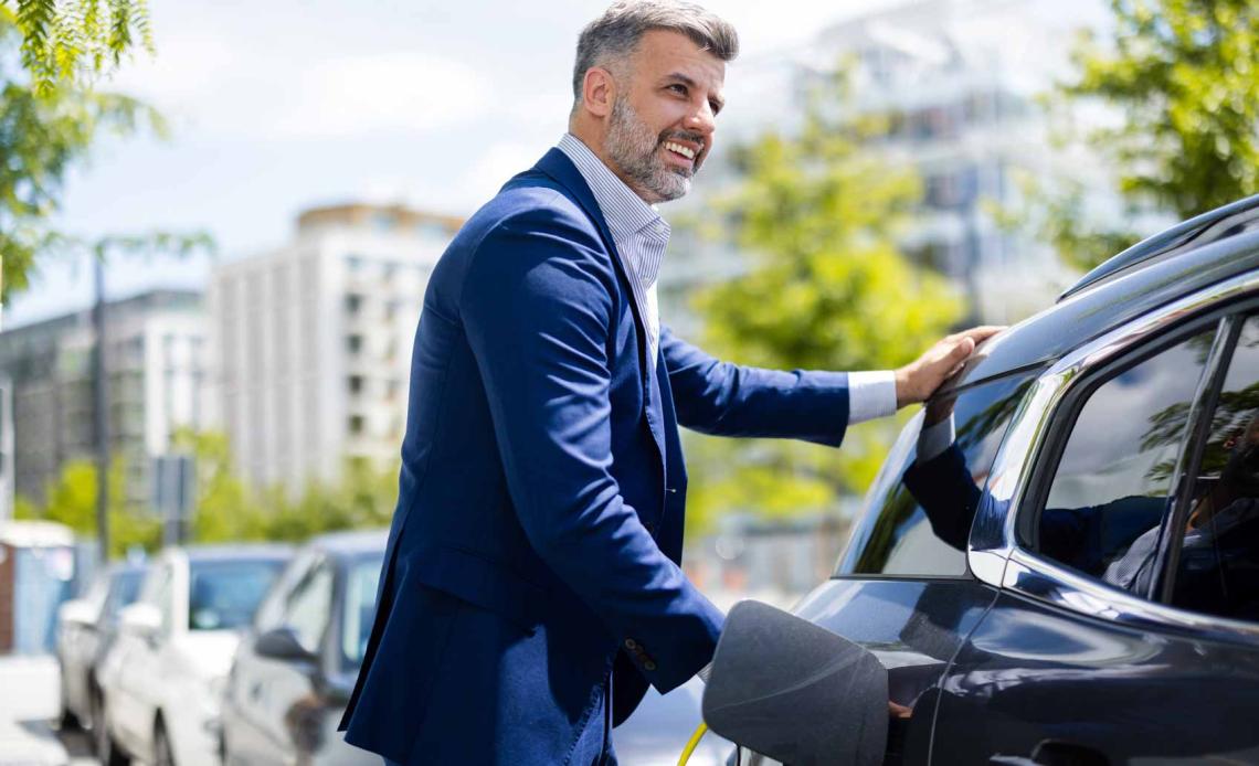 Un homme recharge sa voiture électrique