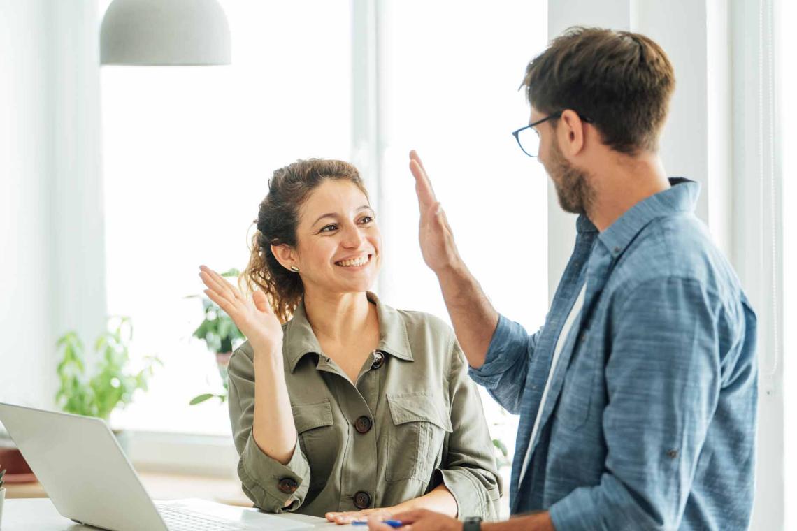 Un homme et une femme semblent se taper dans les mains en souriant