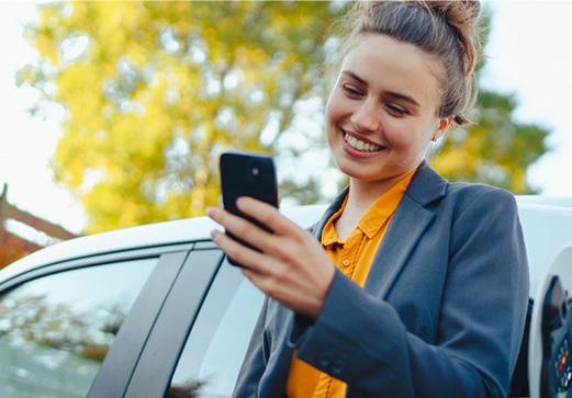 Une femme sourit en regardant son téléphone