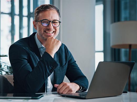 Un homme sourit à son bureau