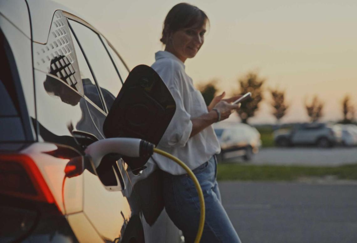 Une femme attend que sa voiture recharge