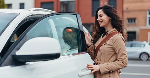 Une femme ouvrant la portière d'une voiture
