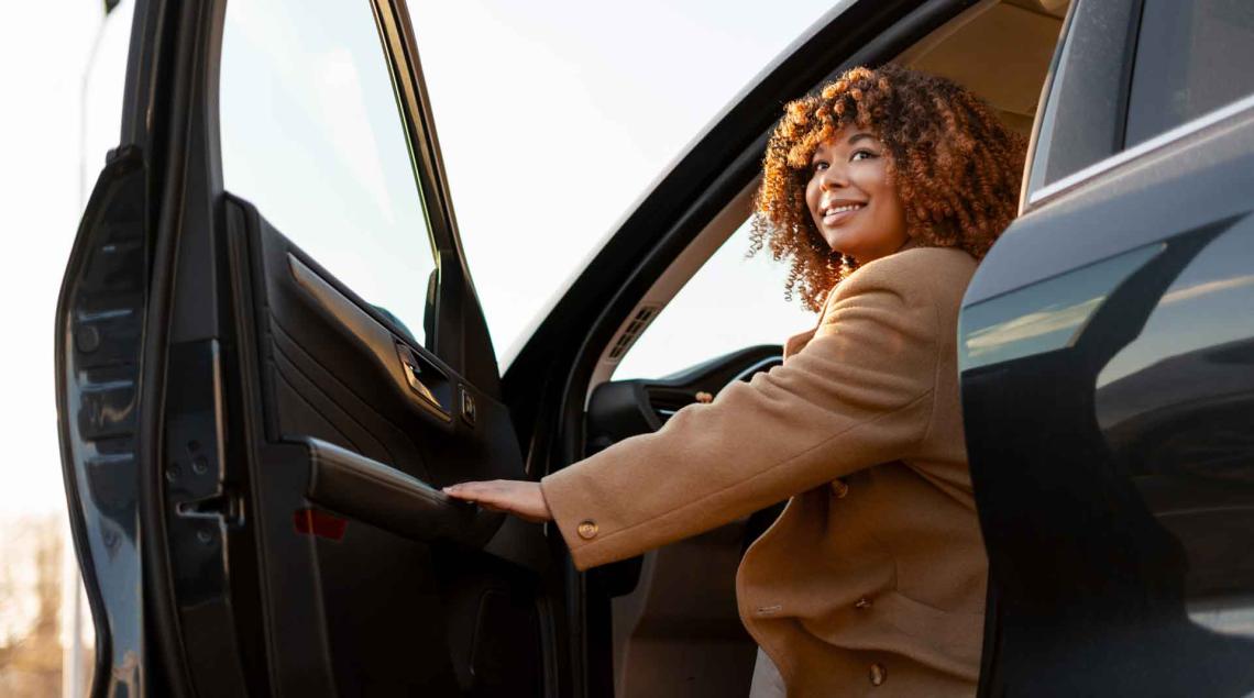 Femme sortant de sa voiture souriant