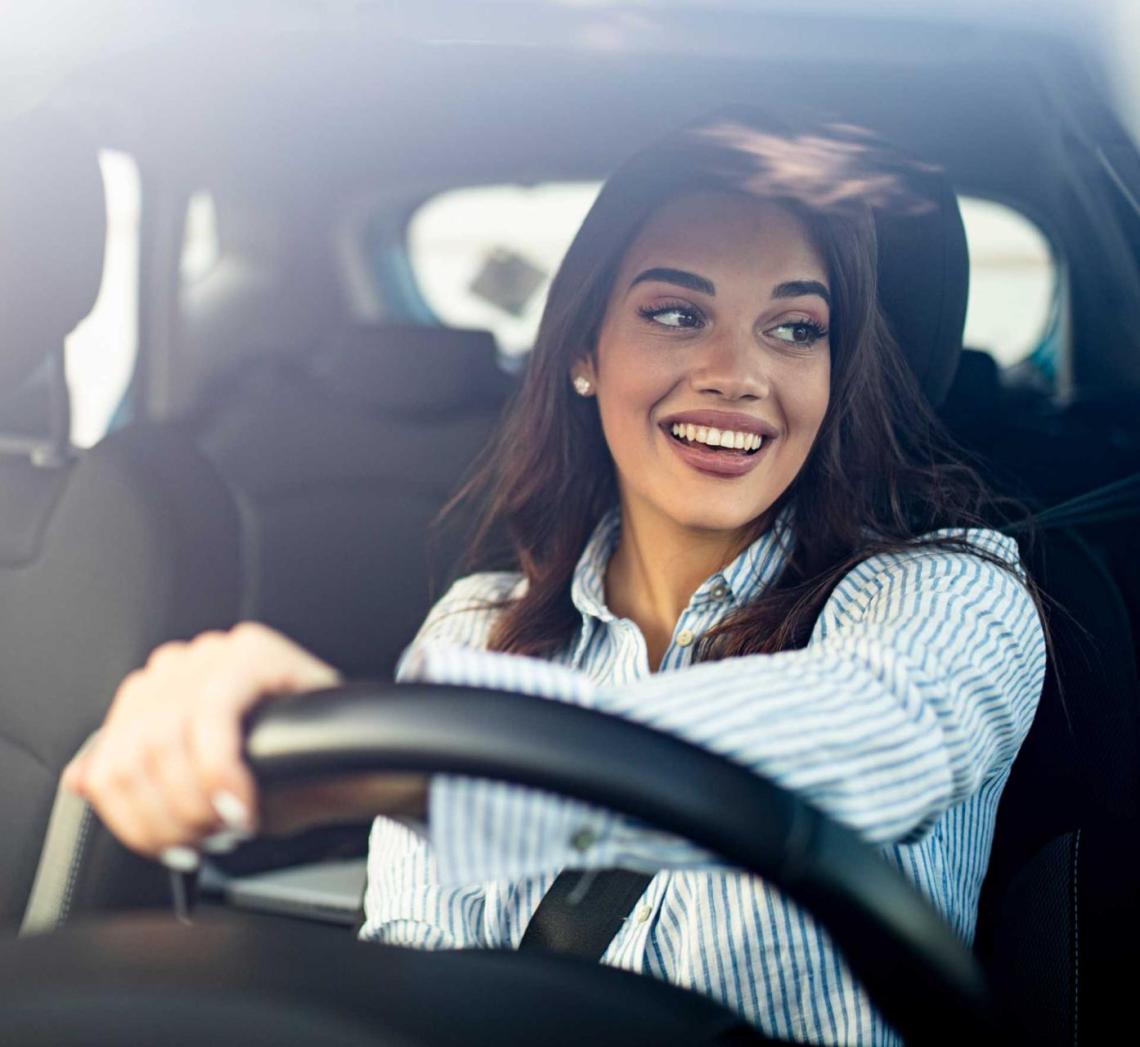 Une femme souriant en conduisant