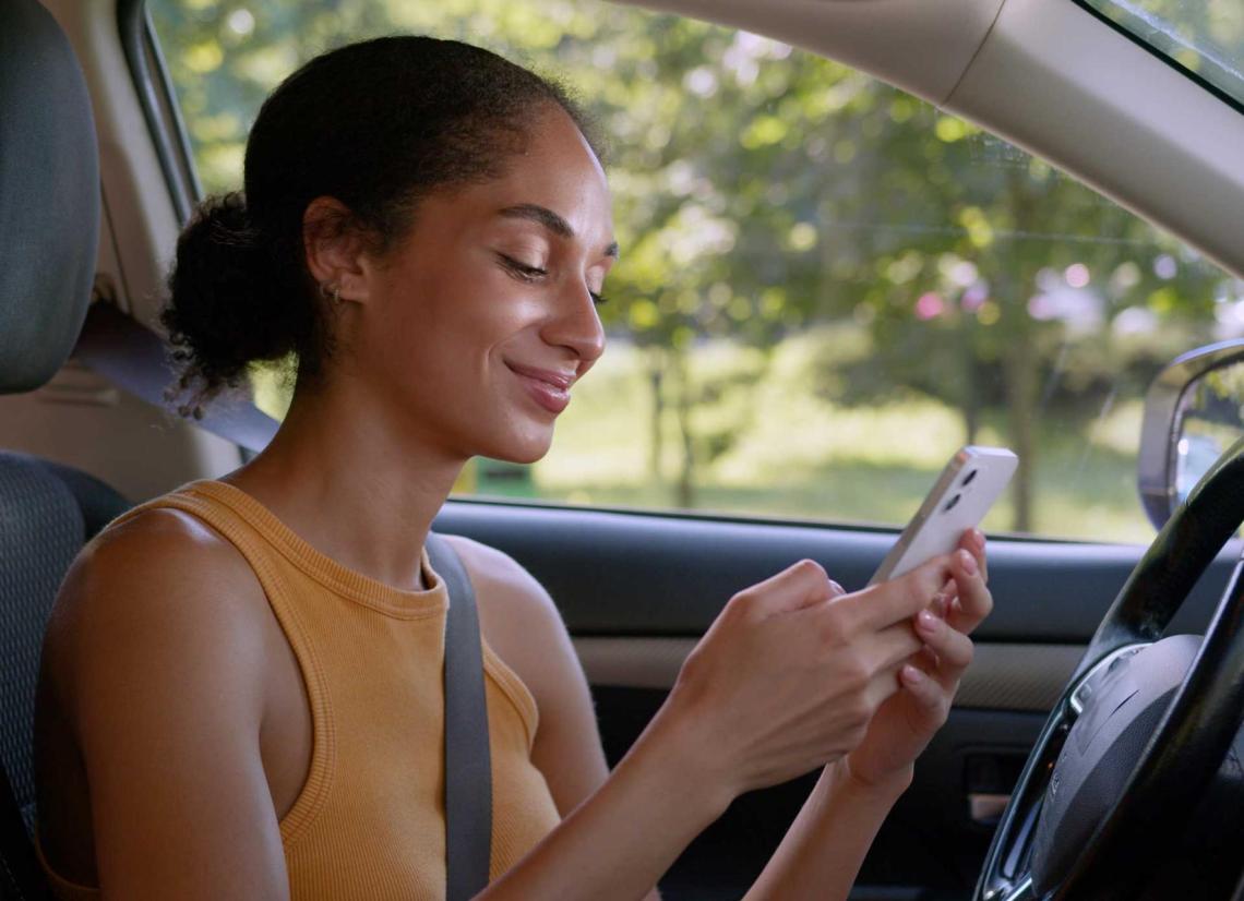 Une femme souris en regardant son téléphone