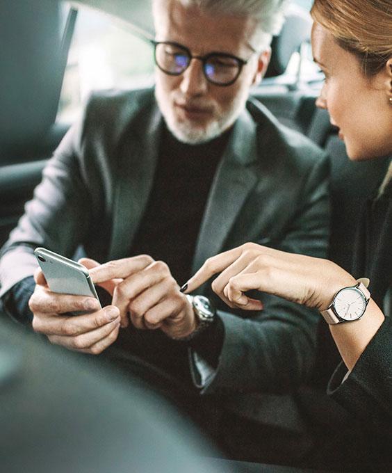 Homme et femme en voiture regardant sur le téléphone