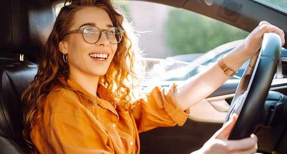 Femme souriante au volant d'une voiture